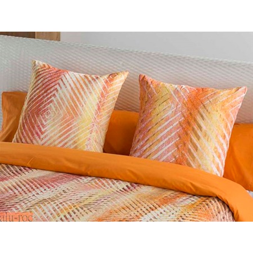 Decorar la cama con textiles estampados y coloridos para dar vida al ambiente